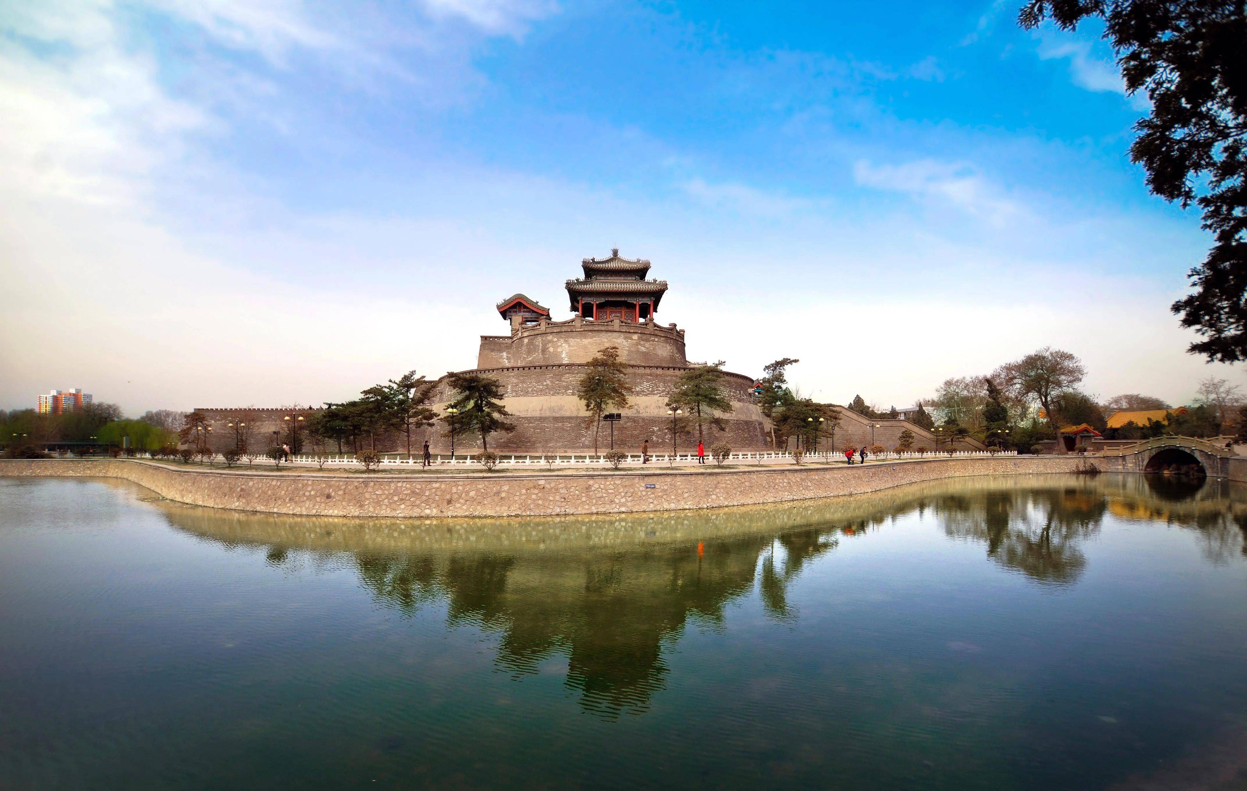 夕阳映照下的邯郸古城，城墙之上，演员凝望田野